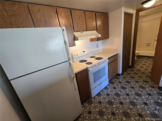 kitchen with brown cabinets, white appliances, light countertops, and under cabinet range hood