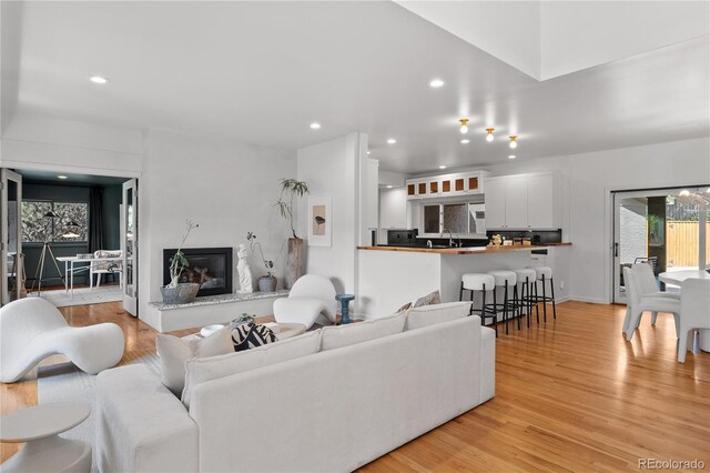 living room with recessed lighting, a fireplace, and light wood finished floors
