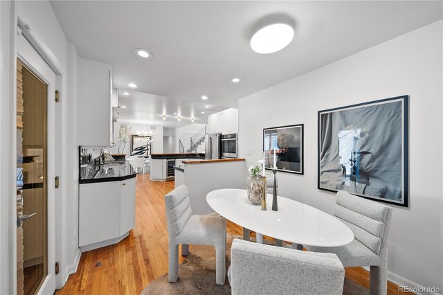dining space featuring light wood-style flooring and recessed lighting