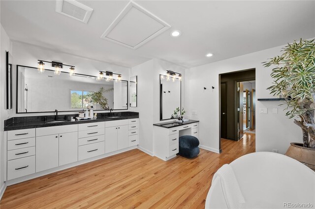 bathroom with recessed lighting, double vanity, wood finished floors, visible vents, and a sink