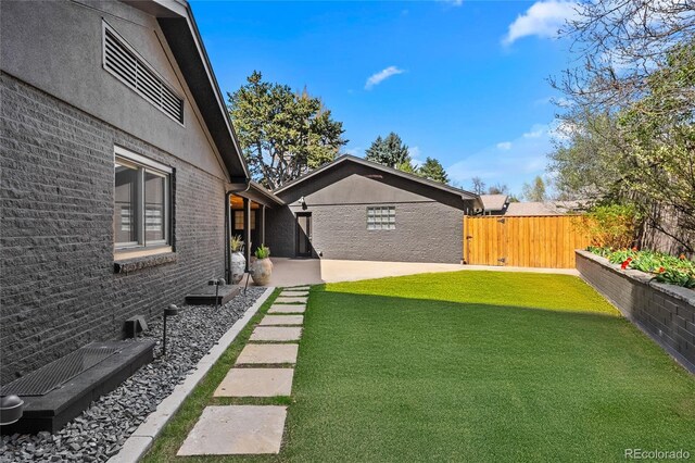 view of yard featuring fence and a patio