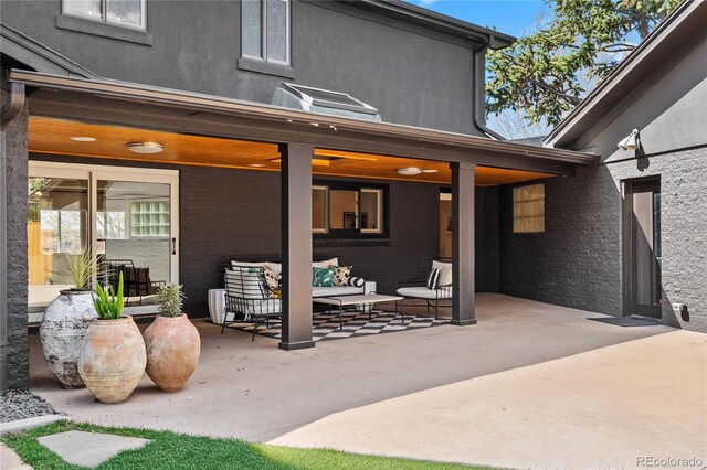 exterior space featuring outdoor lounge area, a patio area, and stucco siding