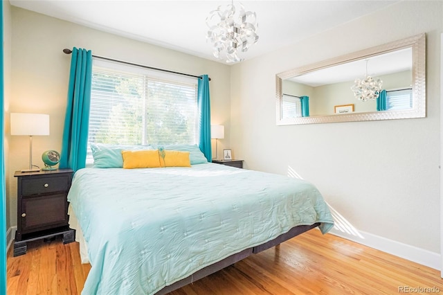 bedroom with hardwood / wood-style flooring and a notable chandelier