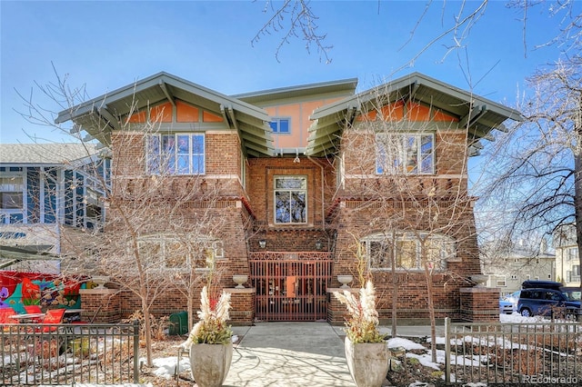 view of front of home featuring brick siding and a fenced front yard