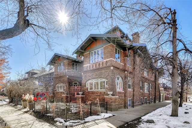 view of front of house featuring a fenced front yard, brick siding, and a chimney