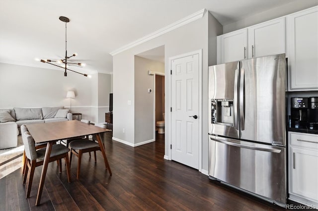 dining space with dark hardwood / wood-style flooring, a notable chandelier, and ornamental molding