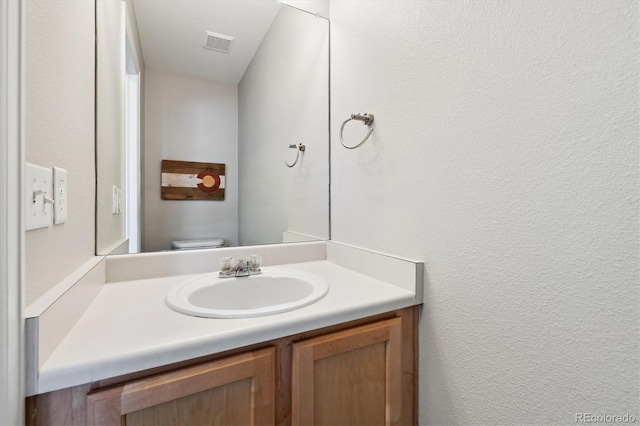 bathroom featuring vanity and toilet