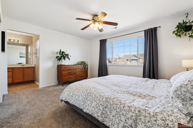 carpeted bedroom featuring ceiling fan, ensuite bath, and sink