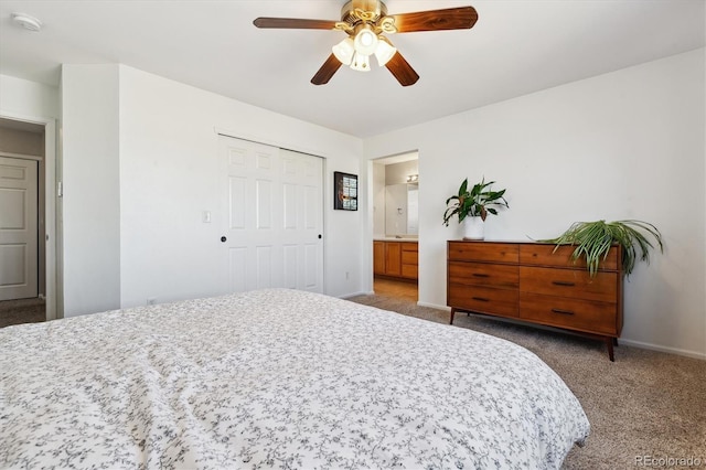 carpeted bedroom with ensuite bathroom, ceiling fan, and a closet