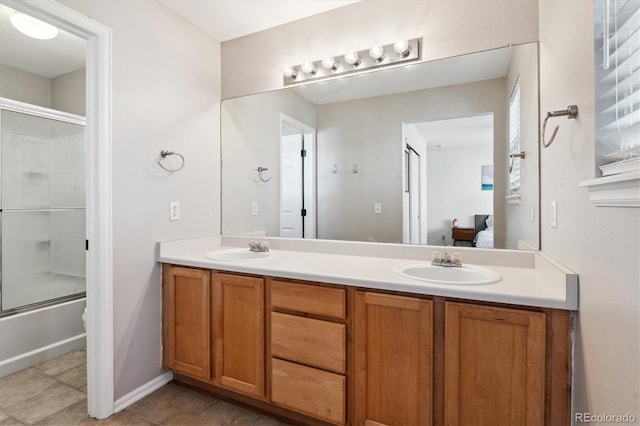 bathroom featuring vanity, tile patterned flooring, and combined bath / shower with glass door