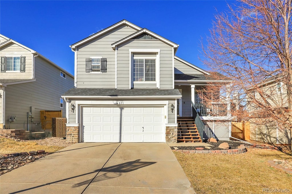 view of front of home featuring an attached garage, stone siding, driveway, and stairs