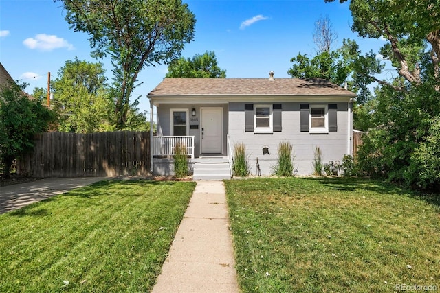 view of front facade featuring a front yard, covered porch, and fence