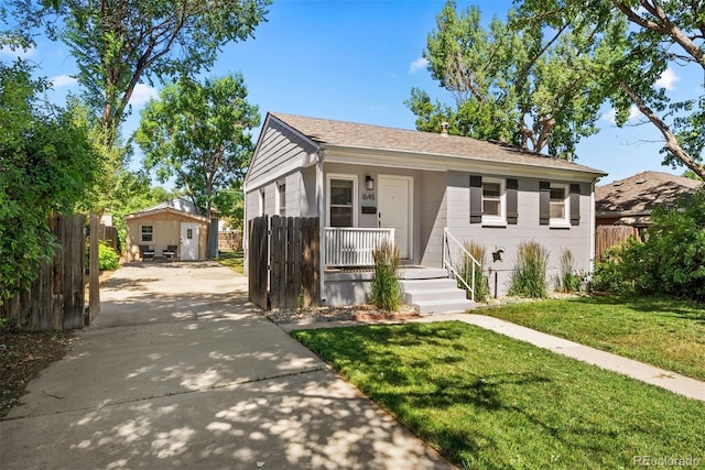 bungalow-style home featuring a front lawn, fence, a porch, and a shingled roof