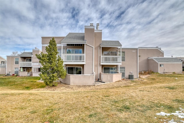 back of property featuring a lawn and cooling unit