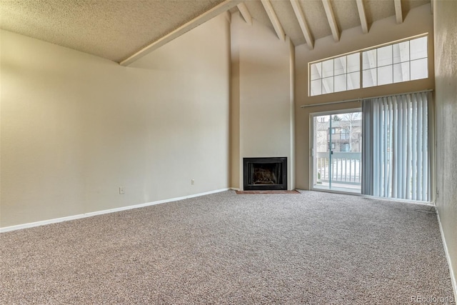 unfurnished living room with carpet flooring, beamed ceiling, high vaulted ceiling, and a textured ceiling