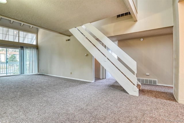 interior space with carpet, a textured ceiling, and a high ceiling