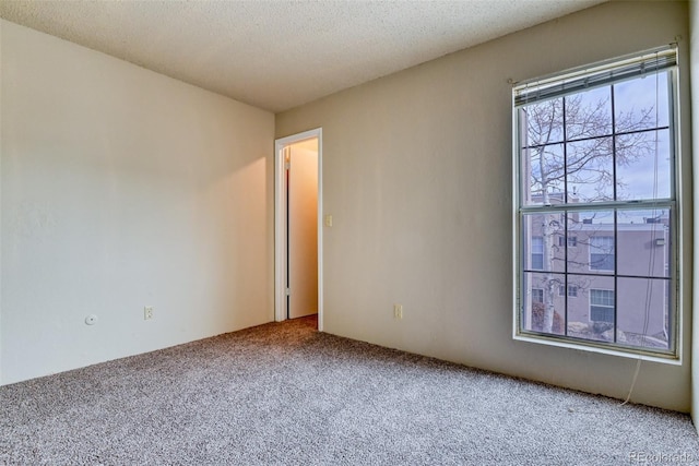 carpeted spare room featuring a textured ceiling