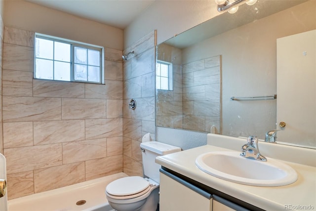 bathroom with vanity, toilet, and a tile shower