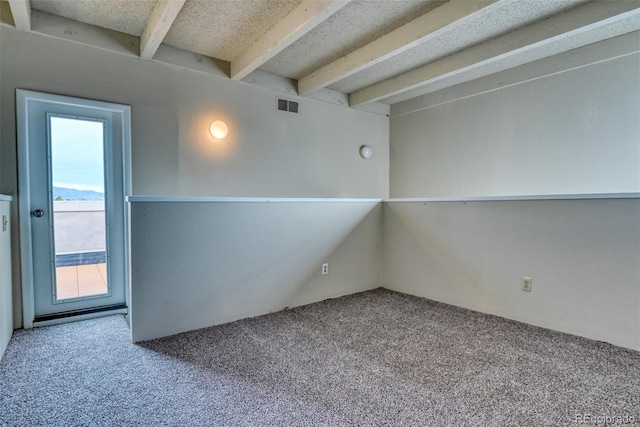 carpeted spare room featuring beamed ceiling