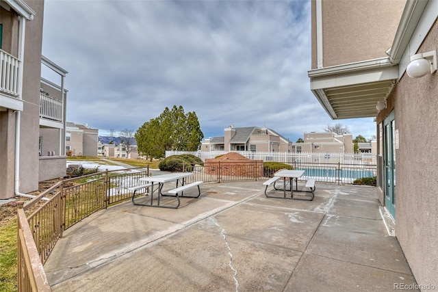 view of patio featuring a fenced in pool and a balcony