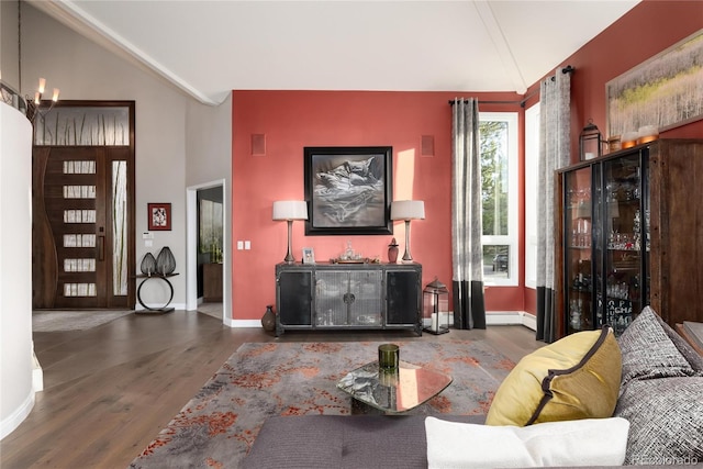 living area with a baseboard radiator, baseboards, wood finished floors, and lofted ceiling