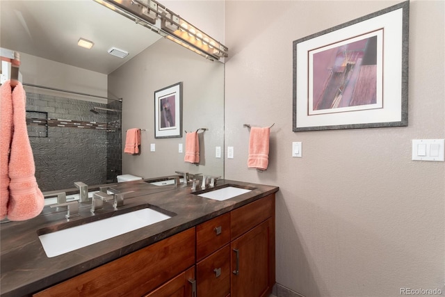 full bath with double vanity, a tile shower, and a sink