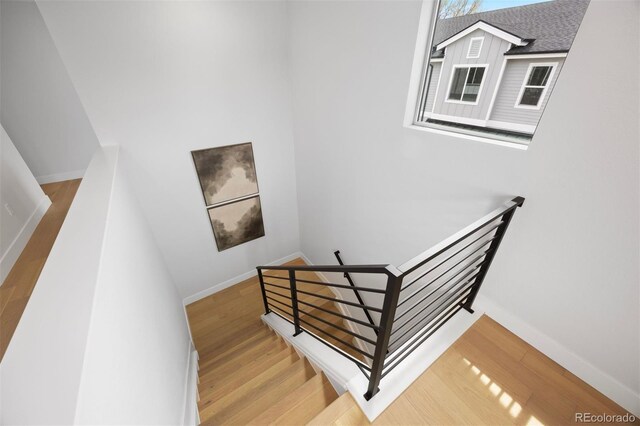 staircase with baseboards and wood finished floors