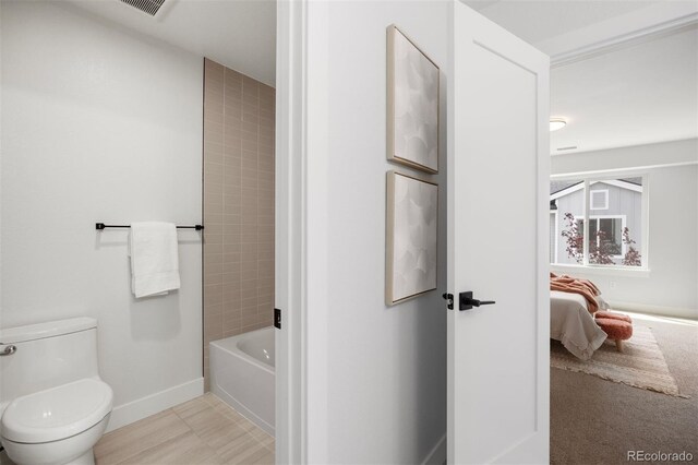 bathroom featuring toilet, connected bathroom, baseboards, and visible vents