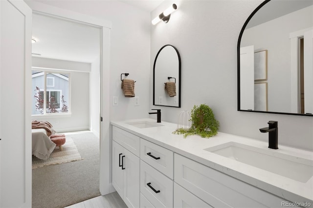 ensuite bathroom with a sink, double vanity, and connected bathroom