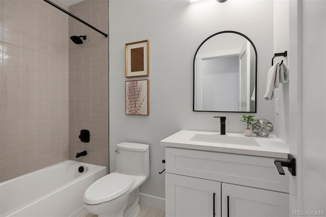 bathroom with vanity, toilet, baseboards, and  shower combination
