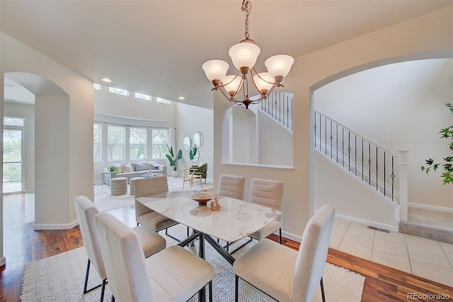 1839 Caleta Trl, Longmont, CO 80504 - dining space featuring arched walkways, healthy amount of natural light, a chandelier, wood finished floors, and recessed lighting