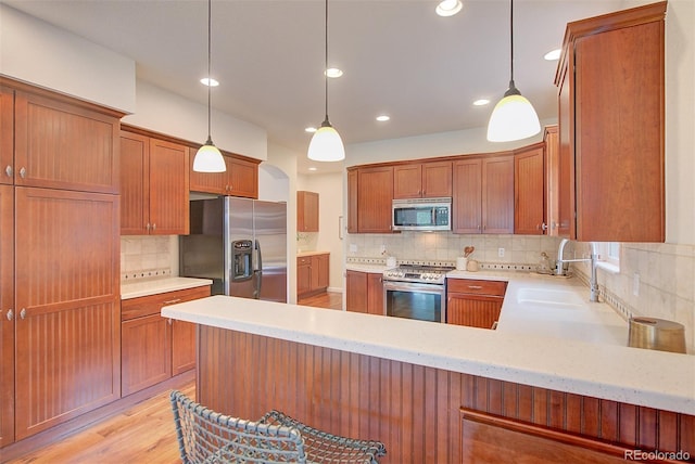 1839 Caleta Trl, Longmont, CO 80504 - kitchen with appliances with stainless steel finishes, tasteful backsplash, recessed lighting, light wood-type flooring, and pendant lighting