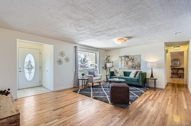 living room featuring wood-type flooring and a textured ceiling