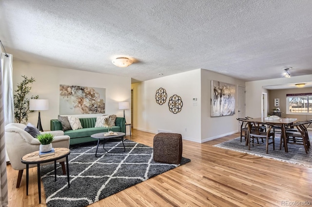 living room with wood-type flooring and a textured ceiling