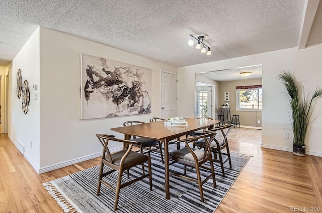 dining room featuring a textured ceiling and light wood-type flooring