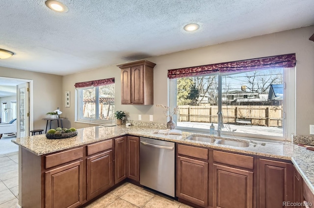 kitchen with dishwasher, sink, kitchen peninsula, and a wealth of natural light