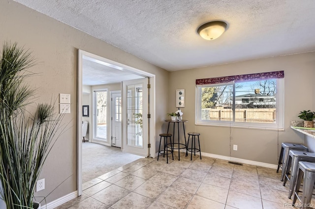 entrance foyer with light colored carpet and a textured ceiling