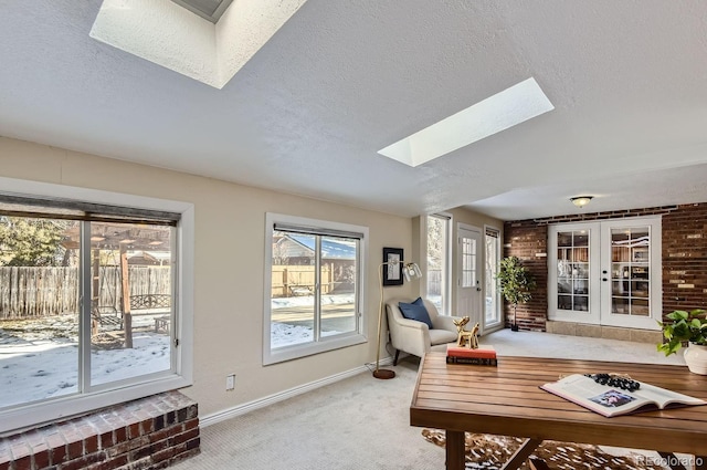 living room with french doors, carpet, a textured ceiling, and a skylight