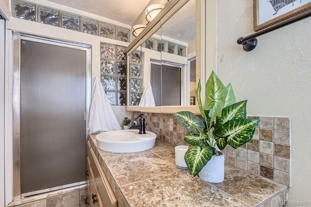 bathroom featuring vanity and backsplash