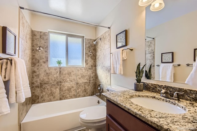 full bathroom featuring tiled shower / bath combo, vanity, and toilet