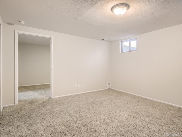 carpeted spare room with a textured ceiling