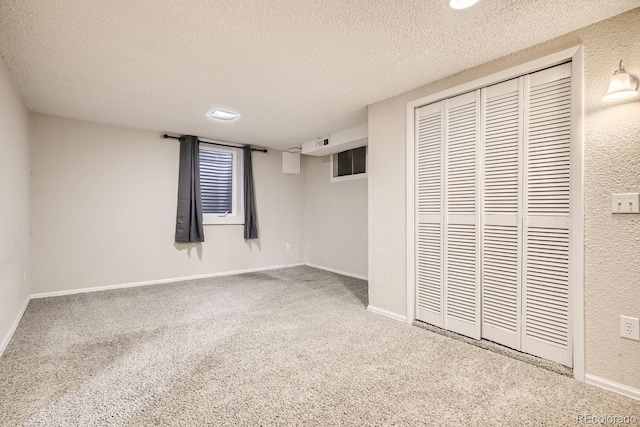 unfurnished bedroom with carpet flooring, a textured ceiling, and a closet