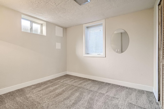 carpeted empty room with a textured ceiling