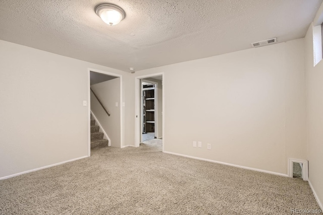 carpeted spare room with a textured ceiling