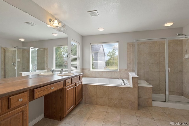 bathroom featuring vanity, plus walk in shower, a textured ceiling, and tile patterned floors