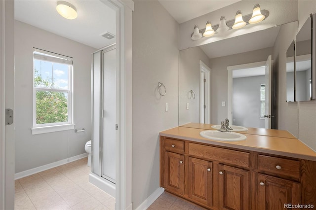 bathroom featuring vanity, toilet, and a shower with shower door