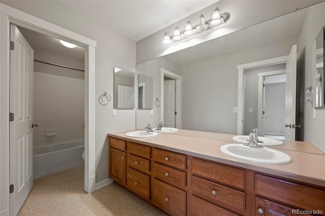 full bathroom featuring tiled shower / bath combo, vanity, and toilet