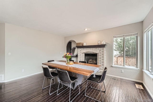 4567 Flanders Way, Denver, CO 80249 - dining space featuring wood finished floors, baseboards, a brick fireplace, and recessed lighting