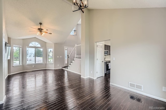4567 Flanders Way, Denver, CO 80249 - unfurnished living room featuring dark wood-style flooring, stairs, a chandelier, baseboards, and high vaulted ceiling