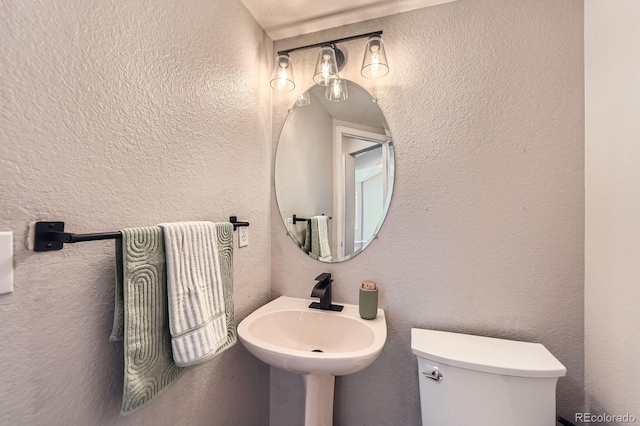 4567 Flanders Way, Denver, CO 80249 - half bathroom featuring a textured wall, toilet, and a sink
